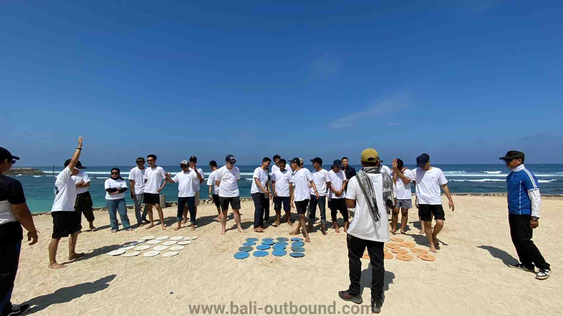Kegiatan outbound team building di Pantai Melasti Bali dengan latar tebing kapur megah
